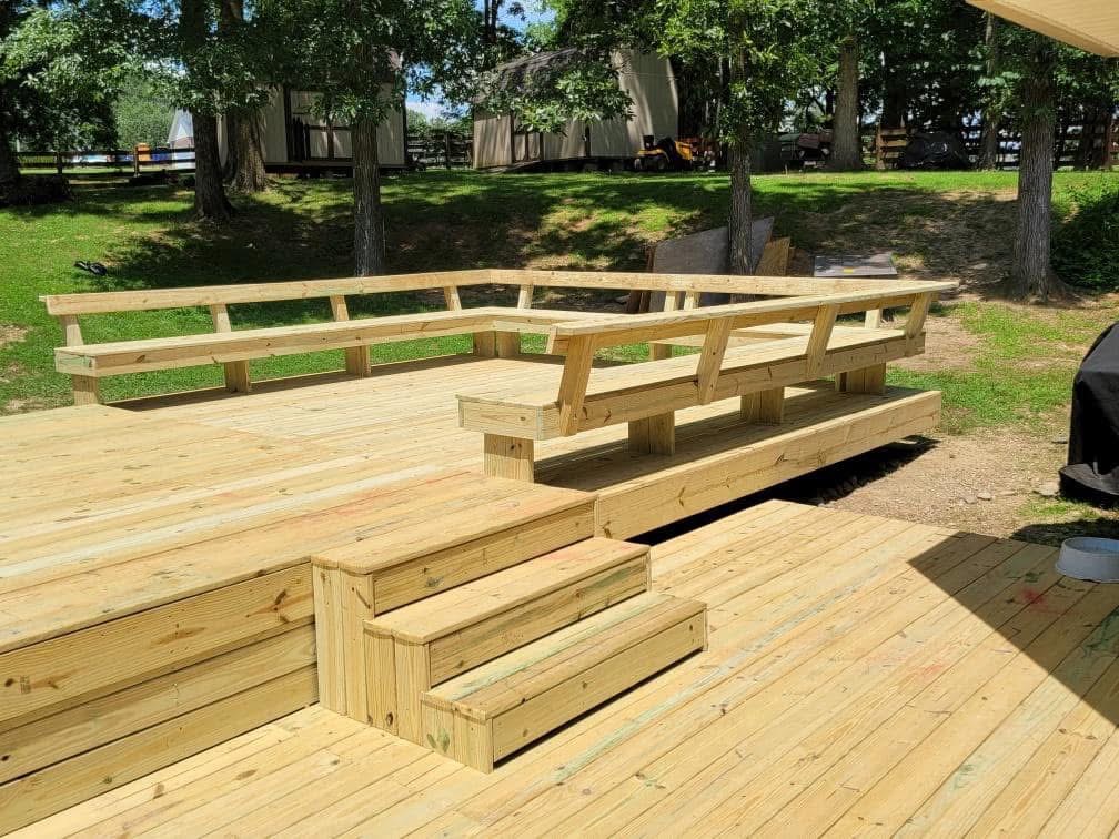 Custom pressure-treated deck with built-in bench seating by Elite Fence & Deck Co.